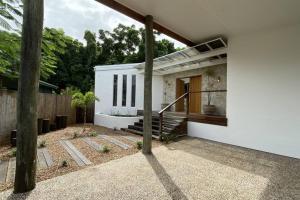 a white house with a staircase and a fence at Casa Tropico - Mission Beach in Mission Beach