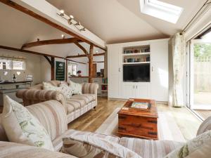 un salon avec des canapés et une télévision dans l'établissement Oast Cottage, à Maidstone