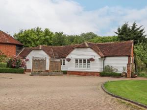 une maison blanche avec une allée en briques dans l'établissement Oast Cottage, à Maidstone