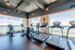 - une salle de sport avec des appareils de cardio-training et de grandes fenêtres dans l'établissement Holiday Inn Shanghai Pudong Kangqiao, an IHG Hotel, à Shanghai