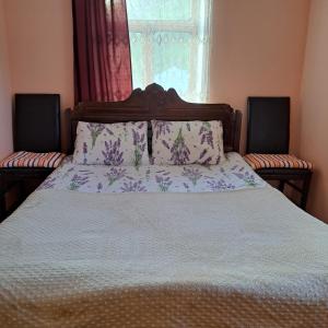 a bedroom with a bed with a white comforter and a window at Chvibiani Guesthouse & Bar in Ushguli
