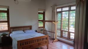 a bedroom with a bed in a room with windows at Mountain View Villa Vacation Rental in Idukki