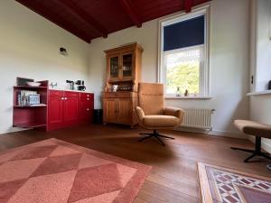 een woonkamer met een stoel en een raam bij BnB Alde Hiemen Friesland 