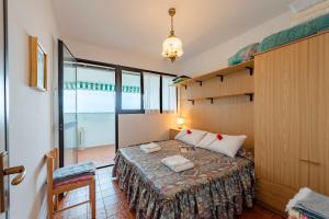 Un dormitorio con una cama en una habitación con ventanas. en Acqua Marina 800m From the Sea - Happy Rentals, en Cogoleto