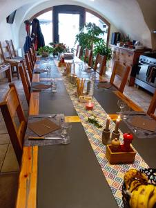 uma longa mesa numa sala com cadeiras e uma mesa em Le Bacchu Ber em Briançon