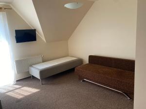 a living room with a couch and a chair at DELFIN Pokoje Gościnne in Gąski