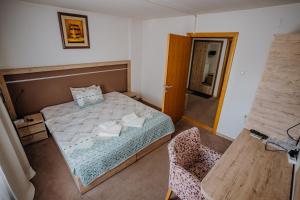ein kleines Schlafzimmer mit einem Bett und einem Stuhl in der Unterkunft Gros Hotel - Leskovac in Leskovac