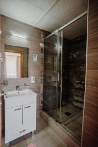 ein Bad mit einer Glasdusche und einem Waschbecken in der Unterkunft Gros Hotel - Leskovac in Leskovac