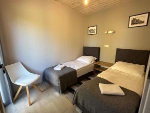 una camera con due letti e una sedia di Domek w centrum miasta a Malbork