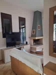 a living room with a tv and a fireplace at Villa Rodi in Galaxidi