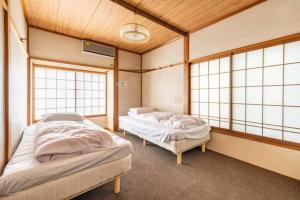 2 Betten in einem Zimmer mit 2 Fenstern in der Unterkunft ザホテル湯沢オリエンタル in Yuzawa
