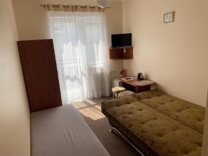 ein kleines Schlafzimmer mit einem Bett und einem Schreibtisch in der Unterkunft DELFIN Pokoje Gościnne in Gąski