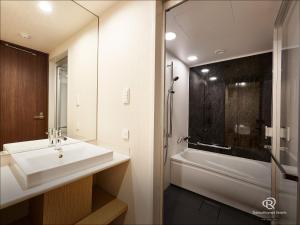 La salle de bains est pourvue d'un lavabo et d'une baignoire. dans l'établissement Daiwa Roynet Hotel Nagoya Fushimi, à Nagoya