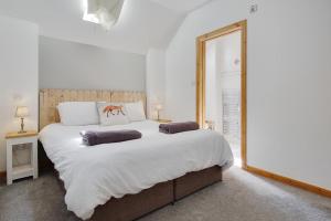 a bedroom with a large bed with two pillows on it at Hilltop Farm in Sturminster Newton