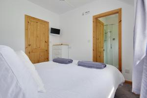 a bedroom with a white bed with two pillows on it at Hilltop Farm in Sturminster Newton
