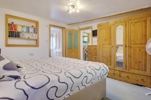 a bedroom with a large bed and a wooden cabinet at Hilltop Farm in Sturminster Newton