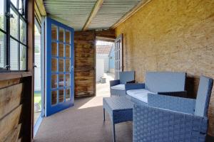 a patio with two chairs and a blue door at Hilltop Farm in Sturminster Newton