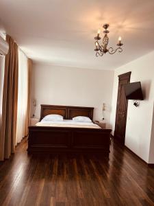 1 dormitorio con cama y lámpara de araña en Едем en Berezhany