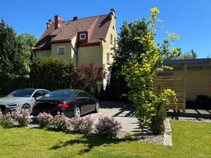 two cars parked in the driveway of a house at Domek w centrum miasta in Malbork +1 photo