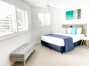 1 dormitorio con cama y banco. en Regatta Noosa en Noosaville
