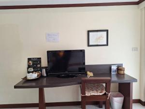 a desk with a television on a wall at Khon Kaen Orchid Hotel in Khon Kaen