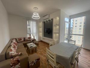 a living room with a couch and a table at Holiday Gateway in Shëngjin