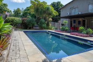 a swimming pool in a yard with a house at High Court Self Catering Apartments in Nelspruit