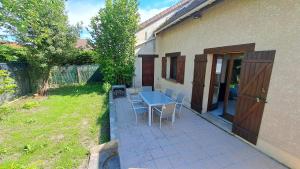 a patio with a blue table and chairs in a yard at House to visit Paris close to Paris, CdG Airport and Villepinte in Aulnay-sous-Bois