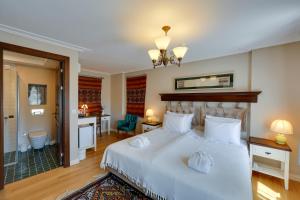 1 dormitorio con 1 cama blanca grande y escritorio en Akanthus Hotel Ephesus en Selcuk
