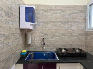 a kitchen with a sink with a stove and a counter top at Cozy Room 1Bhk with Lift 202 in Bengaluru +13 photos