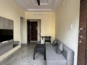a living room with a couch and a table at Cozy Room 1Bhk with Lift 202 in Bengaluru