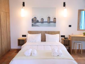 a bedroom with a large bed with two white towels at Chios Shallow Sea in Karfas