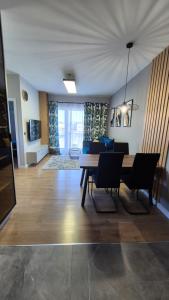 a living room with a table and chairs and a couch at Sweet Home Grabieniec Apartment in Łódź