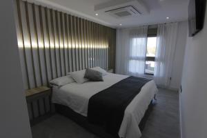 a bedroom with a bed and a large window at El capricho de la ría in O Grove