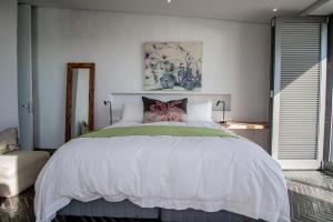 a bedroom with a large white bed in a room at Sonkwas 10 in Paternoster