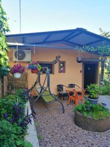 een patio met een blauwe parasol en een tafel bij Little garden house in Rijeka
