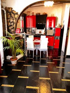 a kitchen with red cabinets and a table with white chairs at Casa Riccio Di Mare in Favignana +13 photos