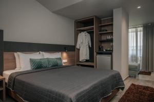 a bedroom with a large bed and a clothes rack at Elizabeth Queen Luxury Rooms in Paralia Katerinis