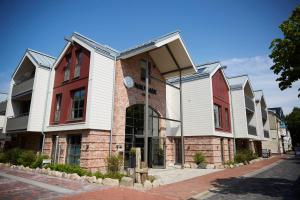 a building with red and white houses on a street at Grand Hotel Nautimar in Büsum