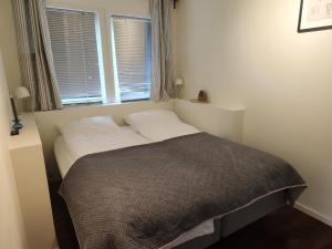 Bett in einem kleinen Zimmer mit Fenster in der Unterkunft Gardemoen Oslo Gjerdrum Residents in Gjerdrum