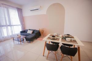 a living room with a table and a couch at Econest Apartment By The one - Educity Nusajaya in Nusajaya