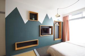 金澤的住宿－Guest Room Tiie，一间卧室,墙上有绿墙,上面有箭头