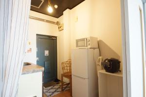 金澤的住宿－Guest Room Tiie，厨房配有白色冰箱和微波炉