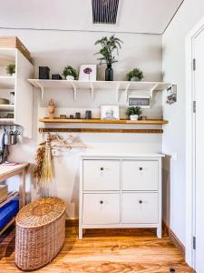 a kitchen with white shelves and a white dresser at Cozy Vertu Ciputra World Studio Apartment in Surabaya by Le Ciel Hospitality in Surabaya