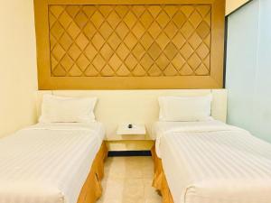 a room with two beds and a table in it at Jakarta City Hotel in Jakarta
