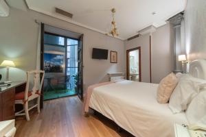 a bedroom with a bed and a desk and a window at Hotel Infanta Isabel by Recordis Hotels in Segovia