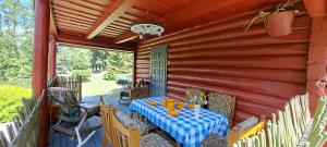 a table on the back porch of a house at Cottage - Liepų Sodyba in Joniškėlis +23 photos