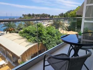 a balcony with a table and chairs and a view of the ocean at Iraklitsa Port View in Iraklitsa