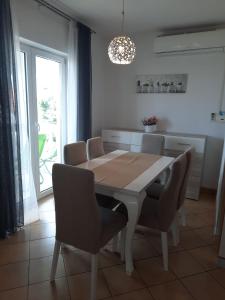 a dining room with a white table and chairs at Apartman Mila in Novi Vinodolski