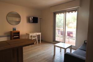 een woonkamer met een bank en een tafel bij L'Amirauté 150m de la plage in Bormes-les-Mimosas